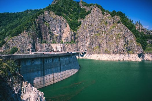 Summer scenery of Vidraru Dam and lake glowing in sunlight. Vidraru Dam, Romania. Carpathian Mountains, Fagaras ridge.