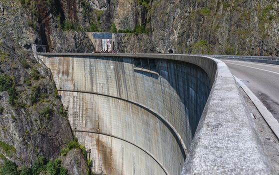 Summer scenery of Vidraru Dam and lake glowing in sunlight. Vidraru Dam, Romania. Carpathian Mountains, Fagaras ridge.