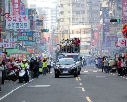 KAOHSIUNG, TAIWAN -- JANUARY 9, 2016: Supporters of DPP presidential candidate Tsai Ying-Wen welcome her motorcade with flags and firecrackers during a campaign event.