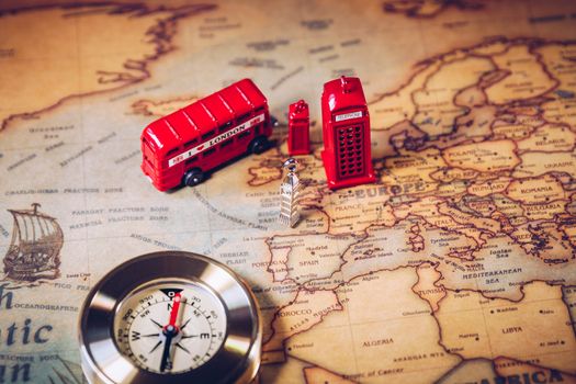 The iconic red bus and Big Ben miniature with compass on the map of London, UK. Concept of travel.