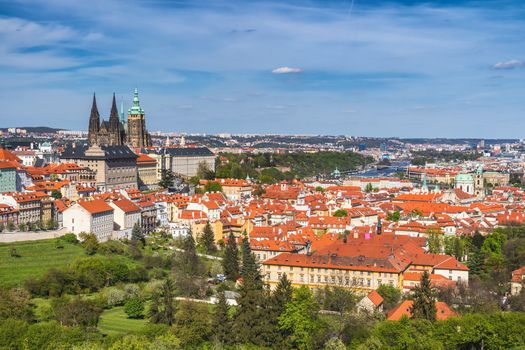 erial view of old Red Tiles roofs in the city Prague, Czech Republic, Europe. Beautiful day with blue sky with clouds in the town.