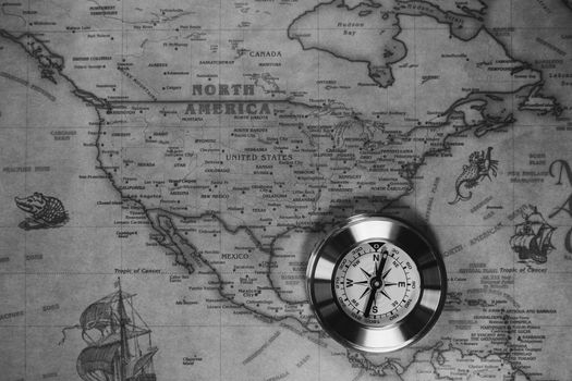 Old compass on vintage map. Adventure stories background. Retro style. The map used for background is in Public domain. Map source: Library of Congress. Country: Belgium Year: 1570. Author: Abraham Ortelius (1527-1598)
