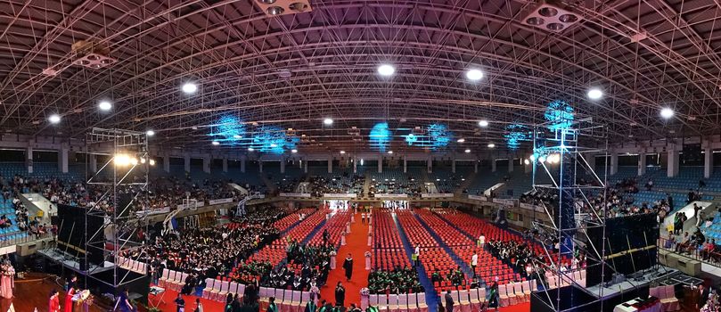 TAINAN, TAIWAN -- JUNE 2, 2018: Graduates enter a large auditorium for the annual graduation ceremony of NCKU university.