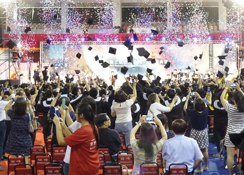 TAINAN, TAIWAN -- JUNE 2, 2018: Graduates throw their caps into the air at the annual graduation ceremony of NCKU university.
