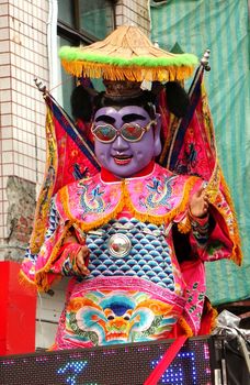 KAOHSIUNG, TAIWAN -- AUGUST 15, 2015: A dancer in a modernized costume of the Chinese Third Prince tradition performs techno dance moves at a local temple carnival.