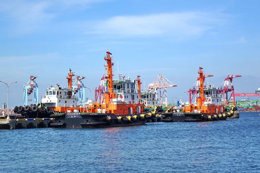 KAOHSIUNG, TAIWAN -- MAY 26, 2018: A line of tugboats are anchored at the Kaohsiung container port in preparation for service.
