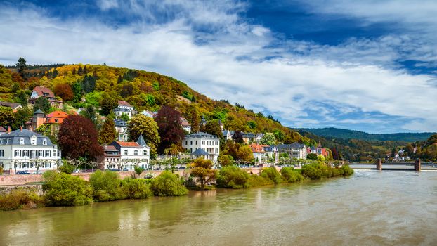 View on Heidelberg in autumn with red foliage including Carl Theodor Old Bridge, Neckar river, Church of the Holy Spirit, Germany