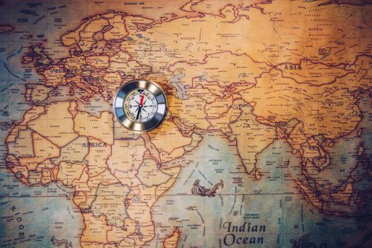 Old vintage retro golden compass on ancient map. Selective focus, shallow depth of field. Concept of world travel, sightseeing and tourism.
