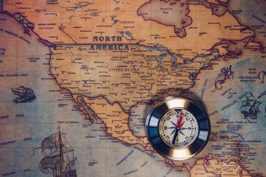 Old vintage retro golden compass on ancient map. Selective focus, shallow depth of field. Concept of world travel, sightseeing and tourism.