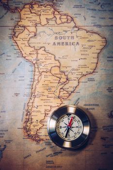 Old vintage retro golden compass on ancient map. Selective focus, shallow depth of field. Concept of world travel, sightseeing and tourism.