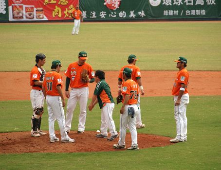 PINGTUNG, TAIWAN, APRIL 8: Players and coach talk with pitcher Wordekemper of the President Lions in Pro Baseball game against the Lamigo Monkeys. The Lions won 2:0 on April 8, 2012 in Pingtung. 