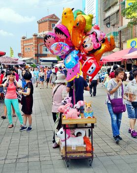 KAOHSIUNG, TAIWAN -- JUNE 27, 2019: A street vendor sells balloons on the main tourist street on Chijin Island.
