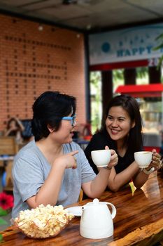 Best friends beautiful asian women drinking coffee and tea with popcorn have a friendship in talking and chatting in cafe coffee shop