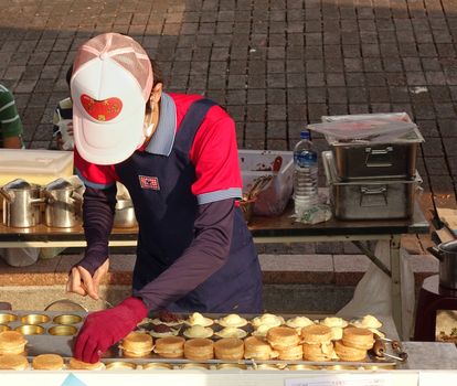 KAOHSIUNG, TAIWAN -- NOVEMBER 8, 2014: An outdoor vendor prepares sweet red bean cakes, a popular Chinese snack.