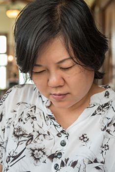 Asian women 40s white skin in white and black dress have a looking and reading a menu or read something in a coffee shop cafe vintage style