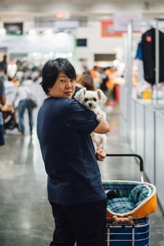 Asian woman feeling happy when her and her pet (The dog) on shopping cart allowed to entrance for exhibit hall or expo