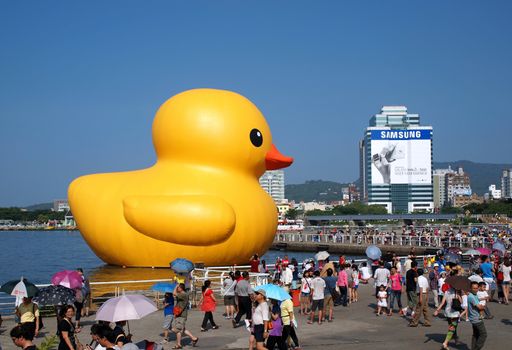 KAOHSIUNG, TAIWAN -- SEPTEMBER 29: Visitors flock to see the giant rubber duck designed by Dutch artist Hofman while it is on display at the Glory Pier on September 29, 2013 in Kaohsiung
