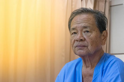 A patient in the hospital, Asian elderly man , process in soft orange sun light style