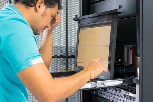 Asia man serious thinking when working on computer server