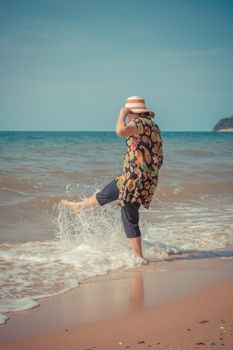 Asia woman plump body in colorful dress with hat posing at beach with blue sea and sky when travel , process in vintage style