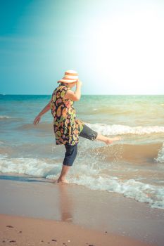 Asia woman plump body in colorful dress with hat posing at beach with blue sea and sky when travel , process in vintage style