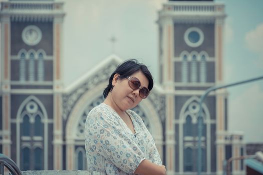 Asia woman plump body with sunglasses standing at Roman Catholic Diocese of Chanthaburi when travel , process in vintage style