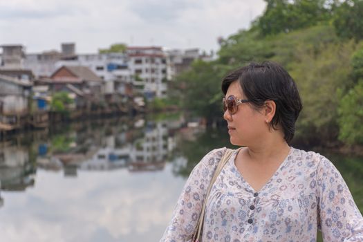 Asia woman plump body with sunglasses standing at river side when travel