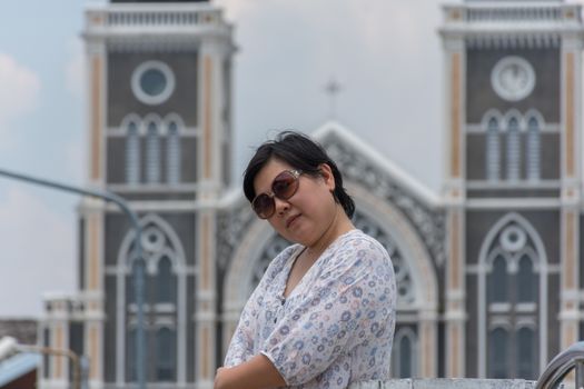 Asia woman plump body with sunglasses standing at Roman Catholic Diocese of Chanthaburi when travel