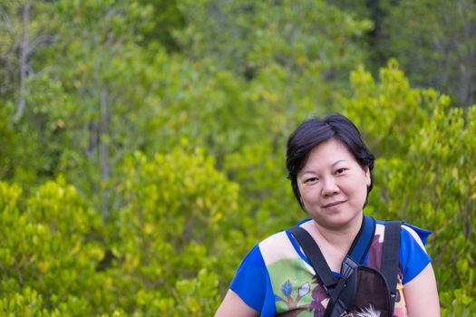 Asia woman plump body in colorful dress posing at Mangrove forrest or Golden Meadow (Thung Prong Thong in Thai language) is a nalure travel point at Rayong, Thailand