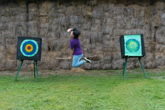 Asia woman plump body is a witch riding a broom flying to archer target