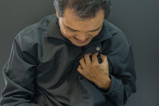 Asia man pain from disease heart attack in black background