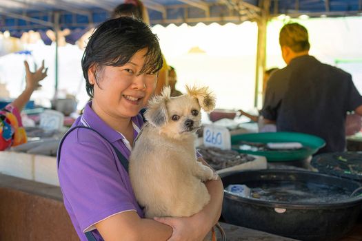 Asia woman and her pet shopping Thai seafood market at Laem Mae Phim Beach on Kram, Klaeng, Rayong, Thailand. , process in soft orange sun light style