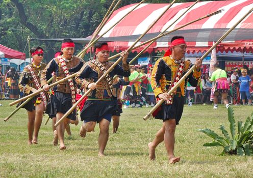 KAOHSIUNG, TAIWAN -- SEPTEMBER 28, 2019: Men with bamboo spears of the indigenous Rukai tribe perform a dance during the traditional harvest festival.
