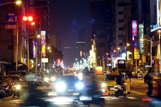 KAOHSIUNG, TAIWAN -- DECEMBER 1, 2018: Busy traffic during evening rush hour in downtown Kaohsiung. The image features motion blur.