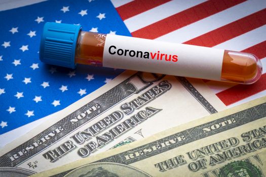 CORONAVIRUS COVID-19 text, US Dollar and blood sample vacuum tube on America flags background. Covid-19 or Coronavirus Concept 
