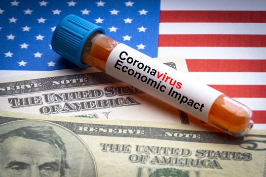 CORONAVIRUS ECONOMIC IMPACT text, US Dollar and blood sample vacuum tube on America flags background. Covid-19 or Coronavirus Concept 