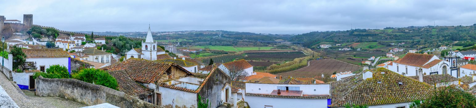 Panoramic view of the old town, with rooftops, and nearby countryside, in Obidos, Portugal