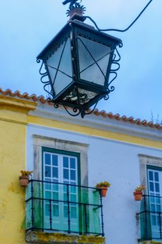 View of a typical street lamp and house windows in Obidos, Portugal