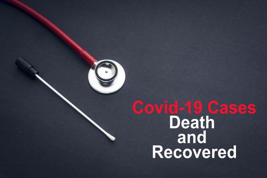 COVID-19 or CORONAVIRUS DEATH AND RECOVERED text with stethoscope and medical swab on black background. Covid-19 or Coronavirus concept. 
