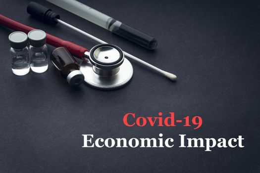 COVID-19 or CORONAVIRUS ECONOMIC IMPACT text with stethoscope, medical swab and vial on black background. Covid-19 or Coronavirus concept. 
