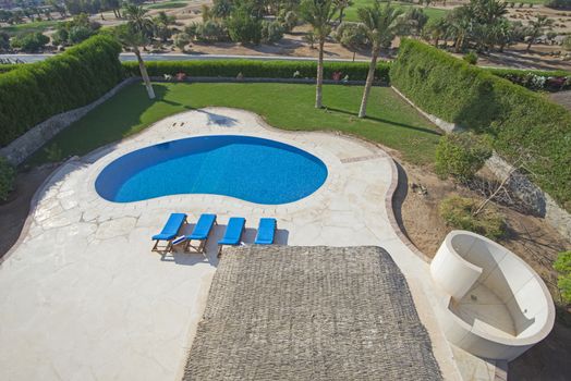 Luxury villa show home in tropical summer holiday resort with aerial view of swimming pool and garden