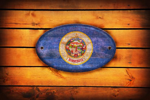 A Minnesota flag on brown wooden planks.