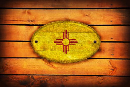 A New Mexico flag on brown wooden planks.