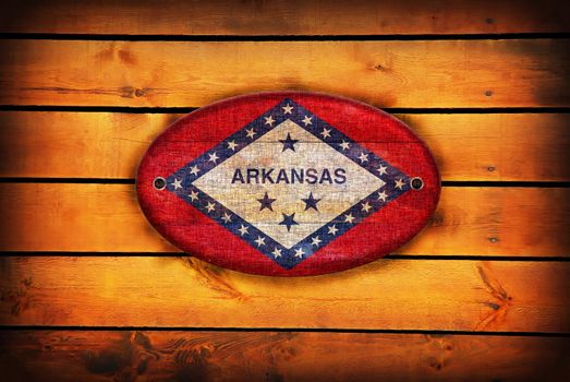 A Arkansas flag on brown wooden planks.