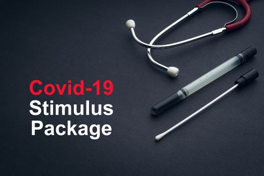COVID-19 or CORONAVIRUS STIMULUS PACKAGE text with stethoscope and medical swab on black background. Covid-19 or Coronavirus concept. 