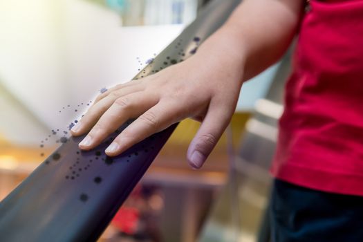 A boy is catching a escalator in an mall with a virus or bacteria.