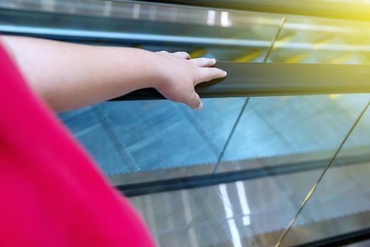 A boy is catching a escalator in an mall