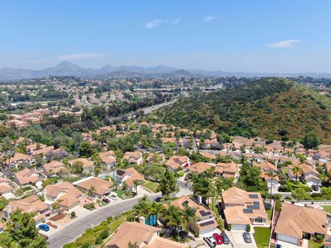Aerial view of middle class neighborhood with residential house with swimming pool and mountain on the background in Rancho Bernardo, South California, USA.