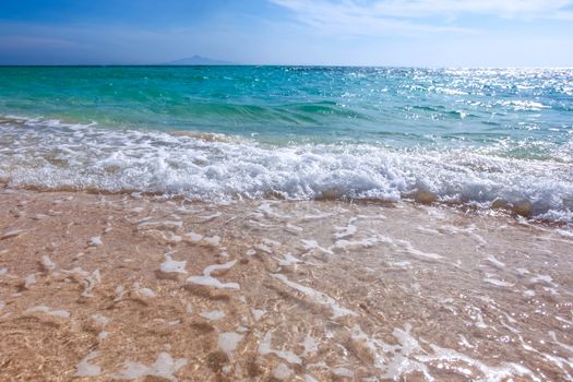 Sand beach and blue sea surf waves close up