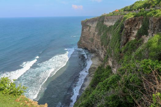 Pura Luhur Uluwatu Temple is a Balinese Hindu sea temple in Bali, Indonesia. It�s renowned for its magnificent location, perched on top of a cliff. Amazing landscape - cliff with blue sky and sea.